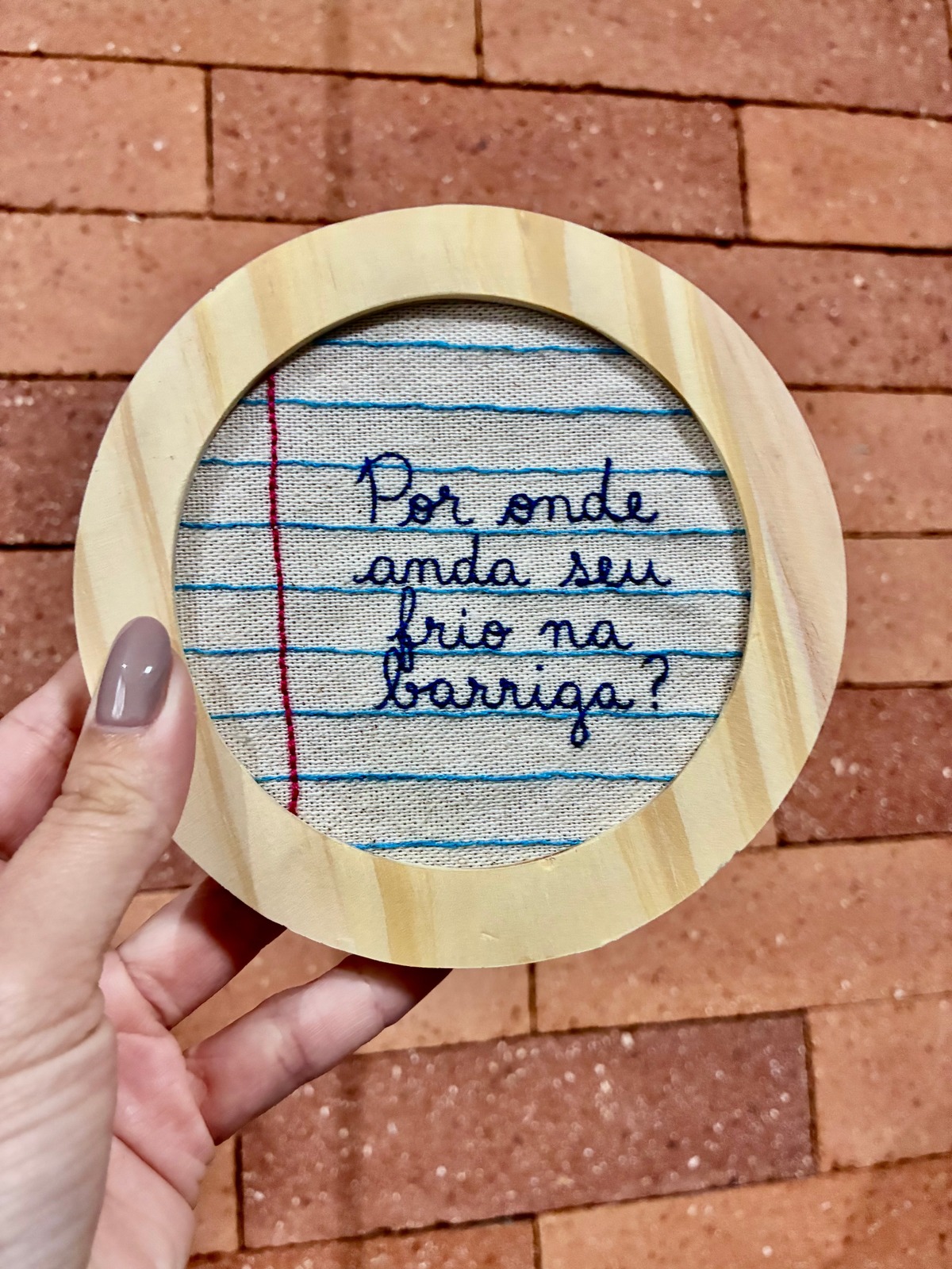 Frase manuscrita bordada sobre linhas de uma folha de caderno